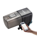 Alimentador automático para peixes com app móvel exibido em smartphone ao lado do produto
