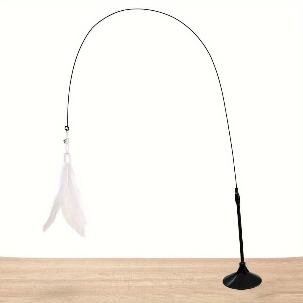 Gato brincando com brinquedo interativo com pena e sino preso na janela com ventosa